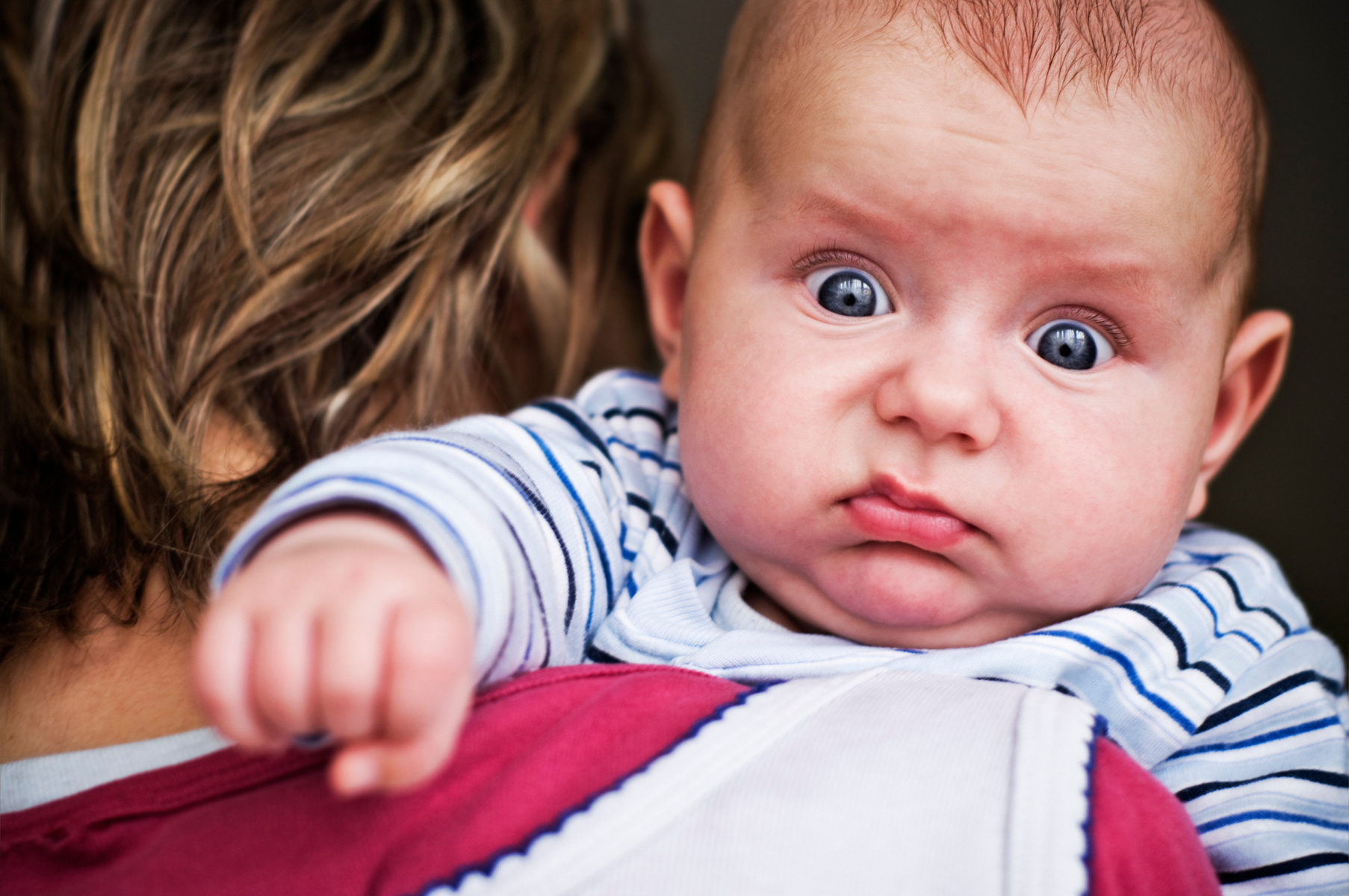 Portrait of a Confused Baby Over a Woman's Shoulder